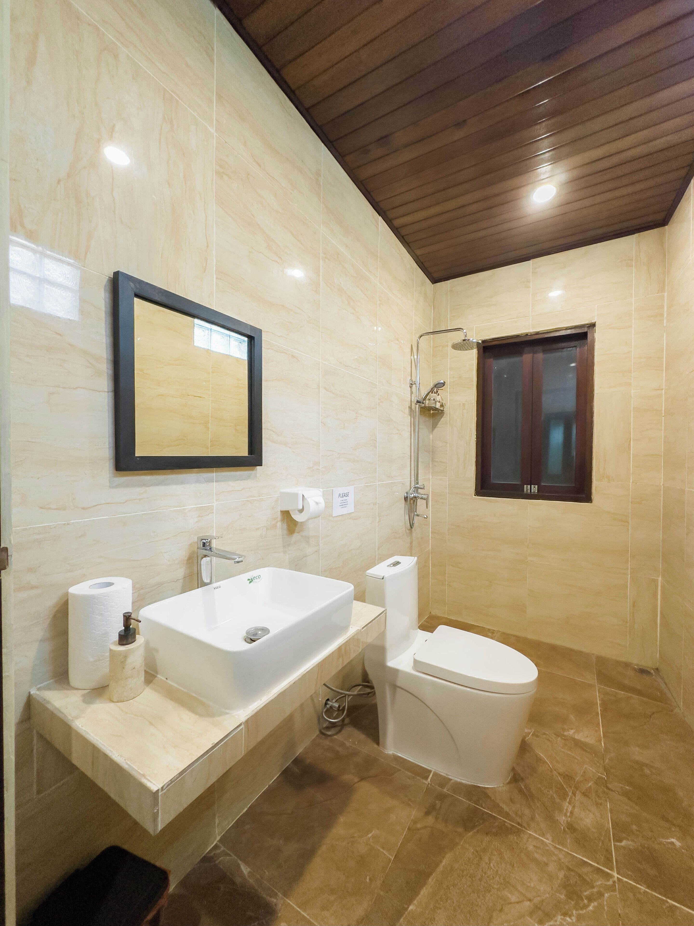 Een moderne badkamer met een groot wastafel, toilet en douche.