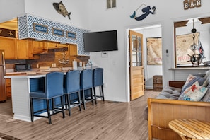 Une cuisine moderne avec un coin bar, un plancher en bois et une décoration sur le thème de la marine.