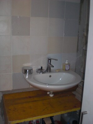 A bathroom with a white sink, a mirror, and a soap dispenser on the countertop. - Gite Rural, restaurant without alcohol/pork (Beurnevésin)