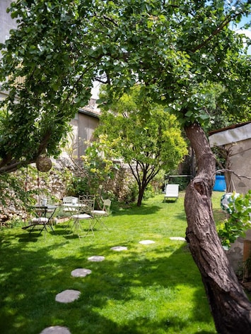 Vue depuis la terrasse sur le jardin arboré