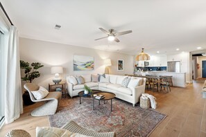 A modern living room with a white sofa, a coffee table, and a patterned rug. - Beautiful Spacious Oceanfront Condo On Isle of Palms (Isle of Palms)