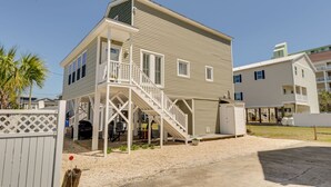 A two-story house with a covered porch and a staircase leading to the upper floor. - Private Beach House, Pet Friendly, Close To Beach + Free Attraction Tickets! (North Myrtle Beach)