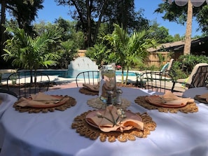 Ein Tisch im Freien, im Hintergrund ein Pool.