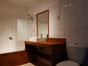 Bathtub, hair dryer, towels, toilet paper