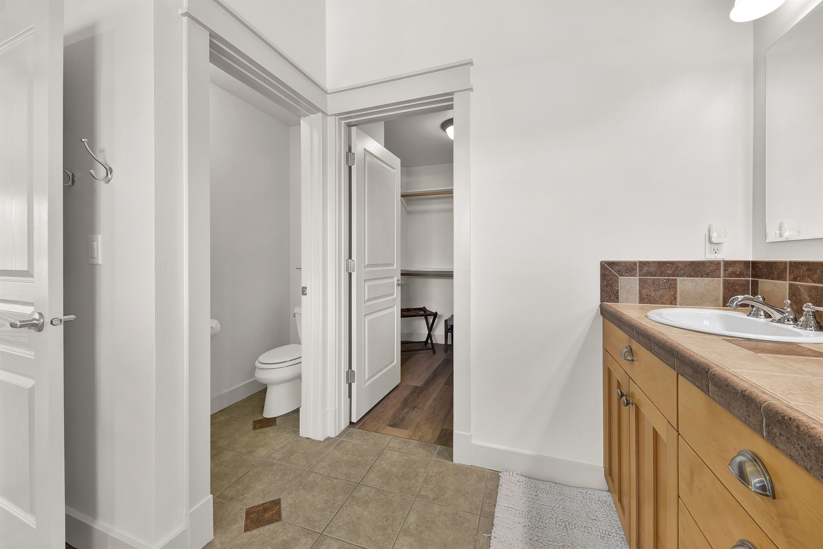A modern bathroom with a sink, mirror, and toilet.