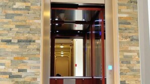 An elevator with a stone wall backdrop and a metallic interior. - Hotel Blagaj (Mostar)