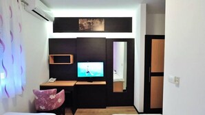 A hotel room with a bed, a desk with a TV, a phone, and a chair. - Hotel Blagaj (Mostar)