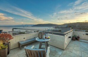 A rooftop terrace with a view of the ocean, a wooden bench, and potted plants. - Retreat to Avila Beach Luxe, short stroll to ocean (Avila Beach)