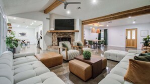 Un salon spacieux doté d’une cheminée, de sièges confortables et d’un coin repas.