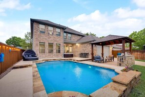 A two-story house with a backyard swimming pool, outdoor seating, and a covered patio area. - Valley Vista Luxury Retreat w Pool, Cinema, Games (Lewisville)