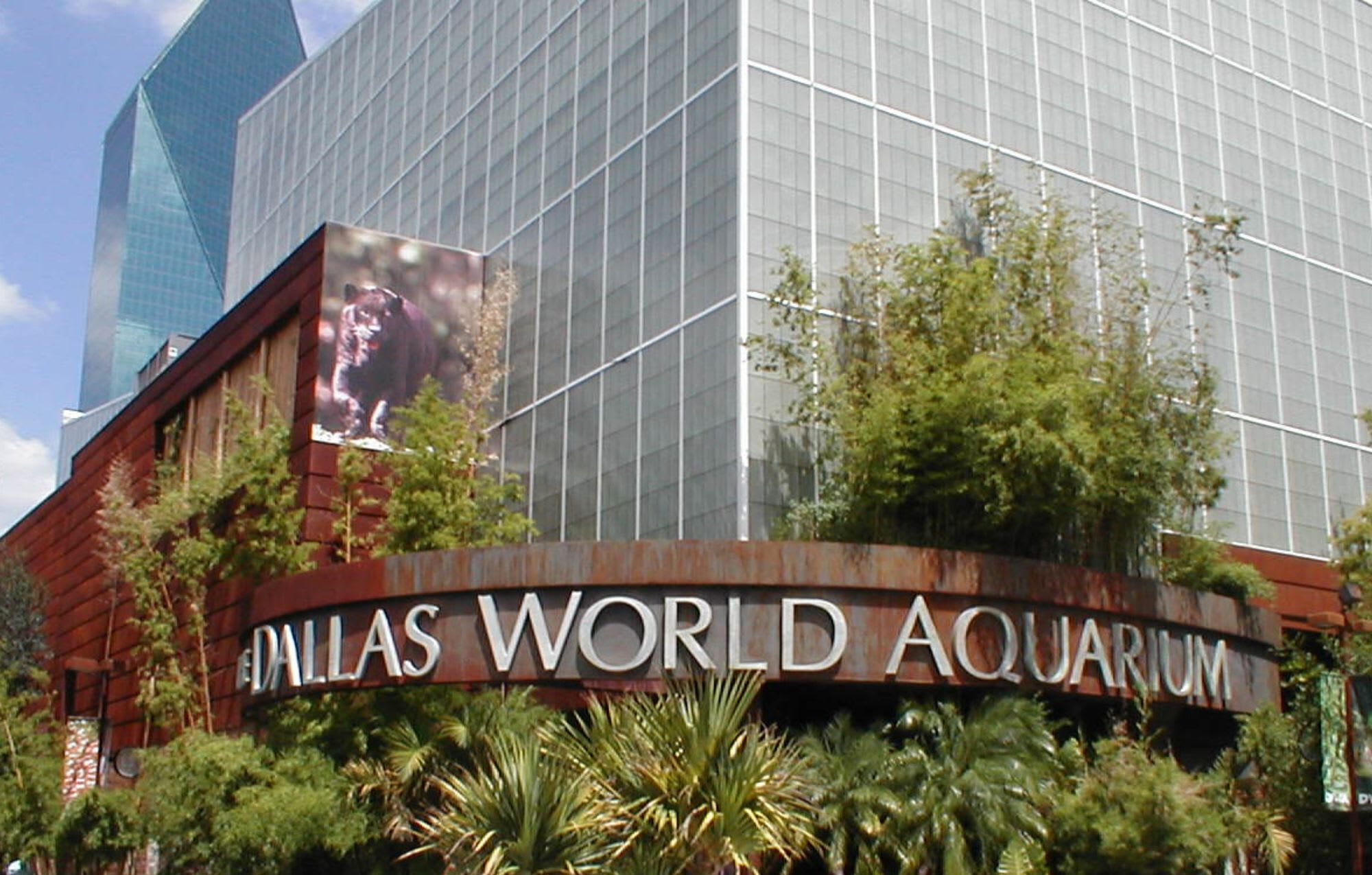 Exterior de l'Aquari Mundial de Dallas, amb una gran façana de vidre i indicadors.