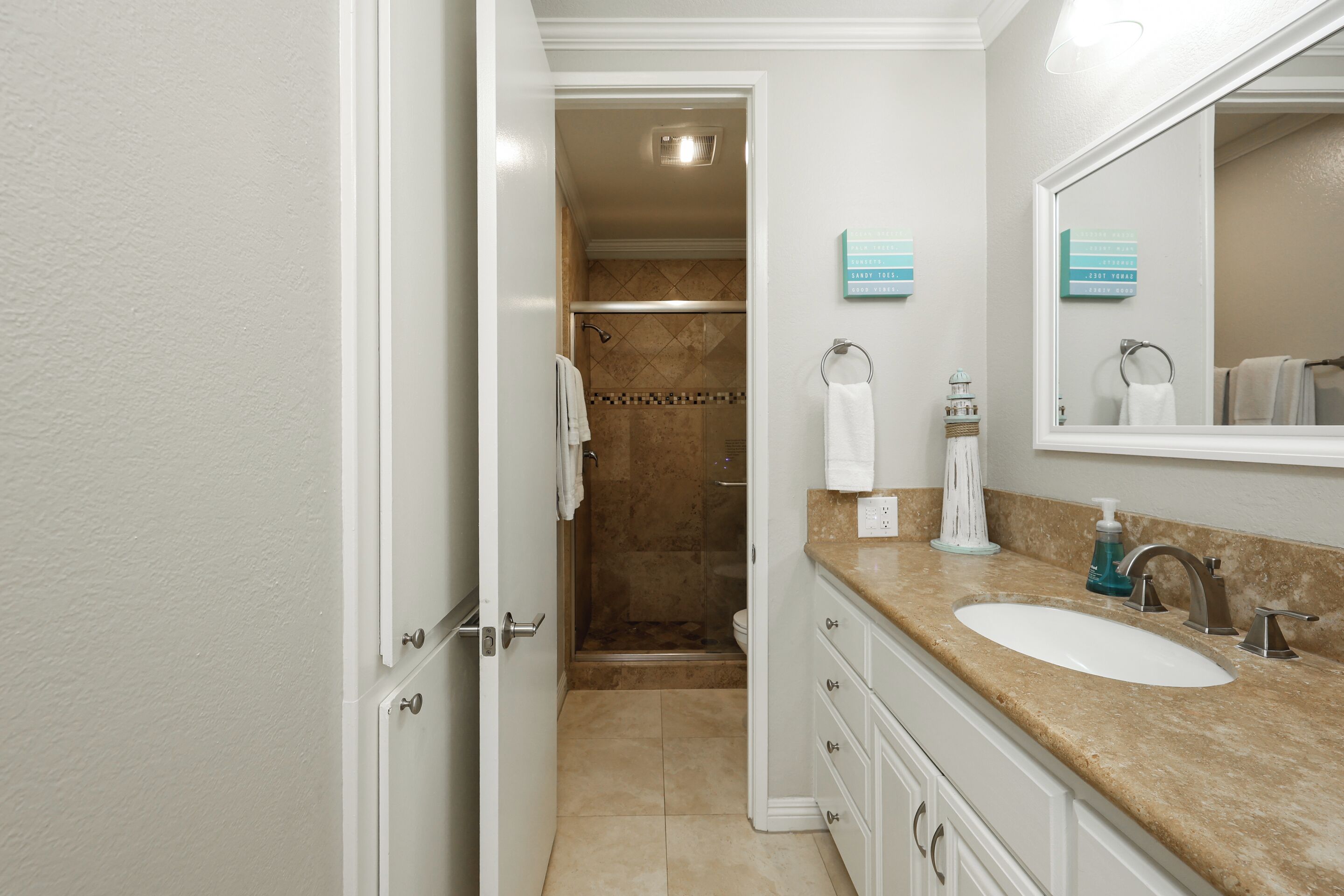 A bathroom with a shower, two sinks, and a large mirror.