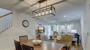A spacious living area with a dining table, comfortable seating, and a large window providing natural light.