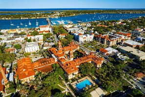 An aerial view of a coastal town with historic buildings, a marina, and a large pool area. - Cheerful studio by LionsBridge, short 🚶‍♀️to downtown. (St. Augustine)
