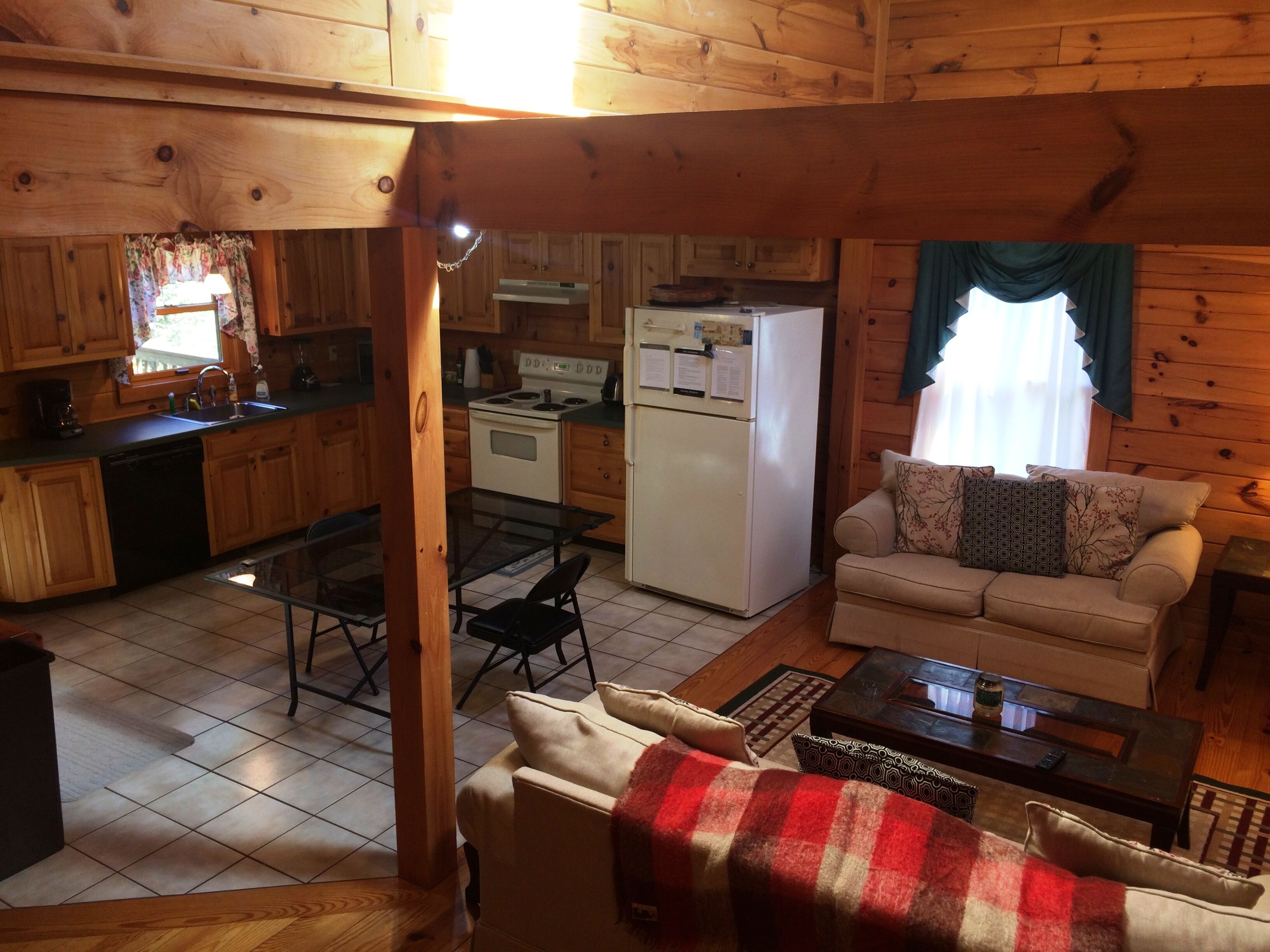 A cozy cabin interior with a dining area, kitchen, and living room.