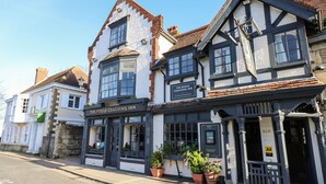 A traditional building with a sign for "The Pugle Coaching Inn" indicating it is a coaching inn. - 8 Munday Cottages (Yarmouth)