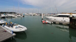 A marina with various boats docked, a wooden dock, and a clear sky. - 8 Munday Cottages (Yarmouth)