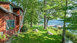A red brick house with a grassy yard, a hammock, and a view of the water. - Lake Winnipesaukee Waterfront Rental Wolfeboro NH Dock Sleeps 13 (Wolfeboro)