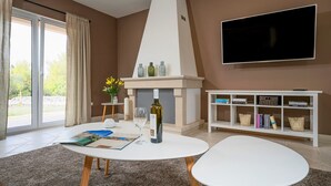 Ein Wohnzimmer mit Kamin, Fernseher und Bücherregal.