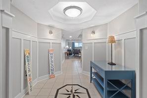 Enter a welcoming hallway leading to a cozy living area with a sofa and coffee table.