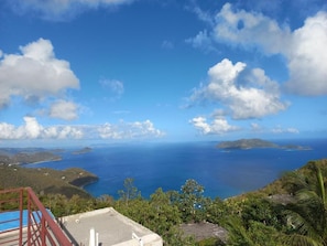 A coastal view with a clear sky, a swimming pool, and lush greenery. - 5 Studio with queen bed & bathroom - 10 min to beach & town (Tortola)