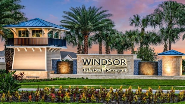 Une enseigne pour le complexe hôtelier Windsor Island Resort, avec un bâtiment moderne et des palmiers.