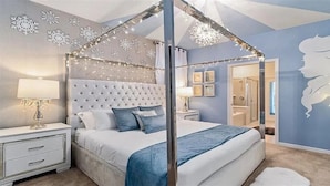 Un dormitorio con cama con dosel, mesitas de noche y tocador.