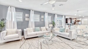 Relax in this stylish living room with a U-shaped sofa arrangement and a large window offering a view.