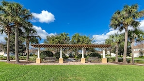 A gazebo with a tiled roof, surrounded by palm trees and a well-maintained lawn. - Last Minute Disney! Private Pool, Hot Tub, Game Room & Themed Bedrooms. Book Now! #56625 (Orlando)