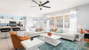 Contemporary living space with a kitchen, sofa, and coffee table.