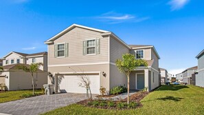 A two-story residential building with a garage, a driveway, and a well-maintained lawn. - Last Minute Disney! Private Pool, Hot Tub, Game Room & Themed Bedrooms. Book Now! #56535 (Orlando)
