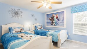 Ein Schlafzimmer mit zwei Betten, einem Deckenventilator, einem gerahmten Bild an der Wand und einem Fenster mit Jalousien.
