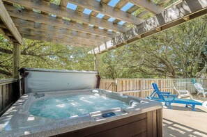 A hot tub under a wooden pergola with a view of trees and a wooden fence in the background. - Allora - Corolla, Ocean Sands, 450 Yds to Beach, Pool, Hot Tub, Pool Table, Gas Fireplace, Pets OK (Corolla)