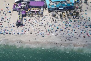 An aerial view of a beach with numerous umbrellas and people.