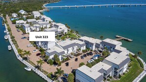 Un hôtel situé sur la côte, composé de plusieurs bâtiments, avec un port de plaisance et un pont en arrière-plan.