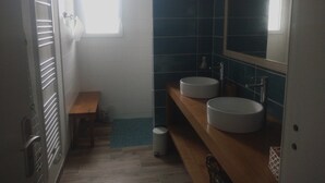 A bathroom with two sinks, a bench, and a window. - Beautiful volumes for this pretty house 50 m from the sea. (La Guérinière)