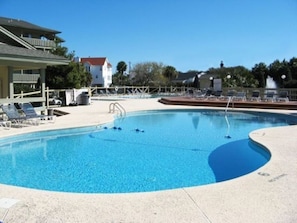 Una piscina con sillas de descanso y un puesto de socorristas.