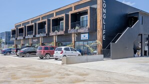 A modern building with multiple balconies, a 'Clean Life' sign, and a 'Long Life' sign.
