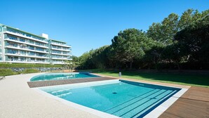 A modern hotel with a pool area, including two swimming pools and a wooden deck. - La Scala Sea Views - by Portugal Portfolio (Cascais)