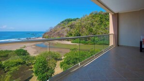 A balcony with a clear view of a beach and forested hillside. - 7th Floor Ocean View. Sleeps 8. 3 Beds 3 Bath (Jacó)