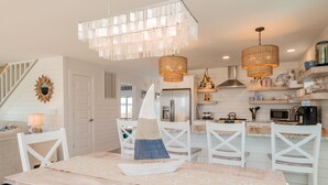 Een keuken met witte kasten, een centraal eiland en een hanglamp.