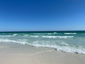 Una playa con cielos despejados y olas.