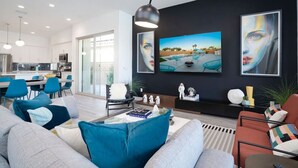A modern living room with a sofa, chairs, a coffee table, and artwork on the wall.