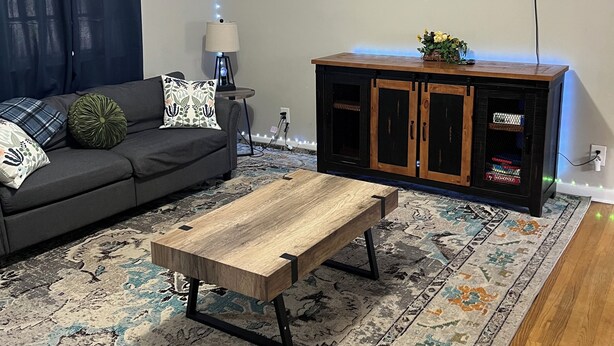 A living room with a sofa, coffee table, TV, and a cabinet. - 3 BR Family Friendly Rambler (Hope Mills)