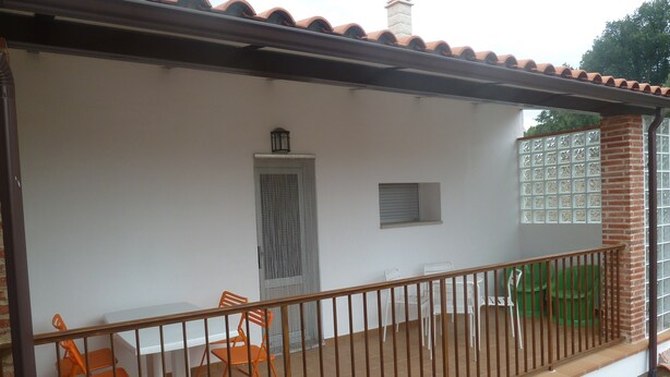 A balcony with a white railing, orange chairs, and a small table. - VoT Rupurupay B (Aldeadávila de la Ribera)
