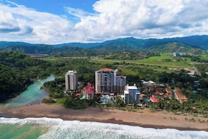 A coastal resort with high-rise buildings, a beach, and a river.