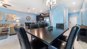 Una sala de estar moderna con comedor, cocina y una mesa de comedor con sillas.