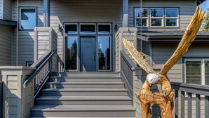 A staircase leading to a house entrance with a wooden sculpture on the right. - Golf-Front Luxury | 3 King Suites | Private Hot Tub | Eagle Crest Resort (Redmond)
