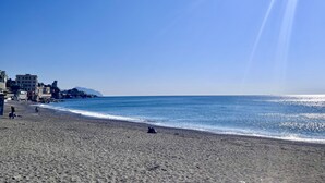Une plage avec des bâtiments en arrière-plan et un ciel dégagé.