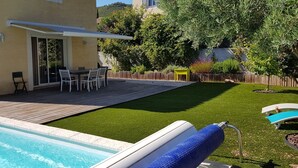 A backyard with a swimming pool, a patio with outdoor furniture, and a well-maintained lawn. - Villa in Provence well located, 90M2 with swimming pool (Auriol)
